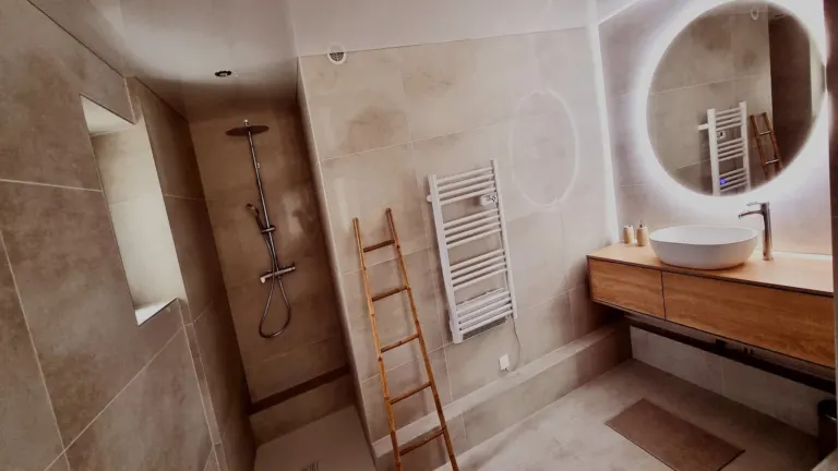 Douche à l'italienne et miroir rond lumineux de la salle d'eau