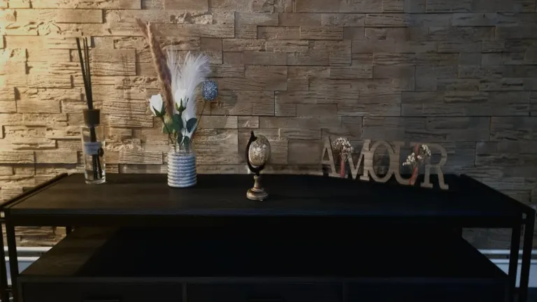 Console décorée de pampas et de lettres « Amour » devant un mur de pierre