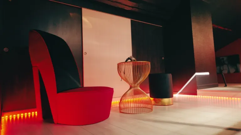 Fauteuil escarpin rouge et éclairage rouge dans la pièce secrète