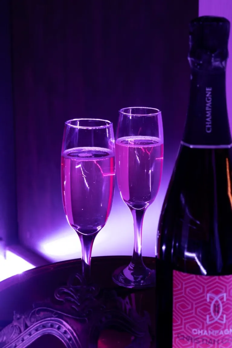 Deux coupes de champagne rosé sous une lumière violette