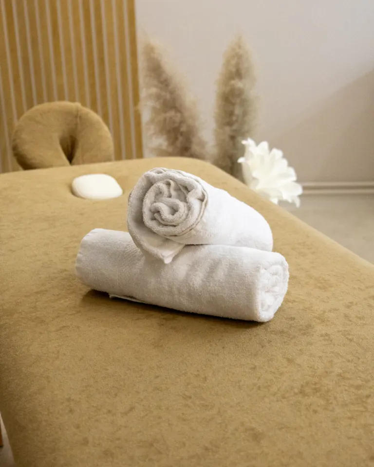 Serviettes roulées sur la table de massage, décor de pampas