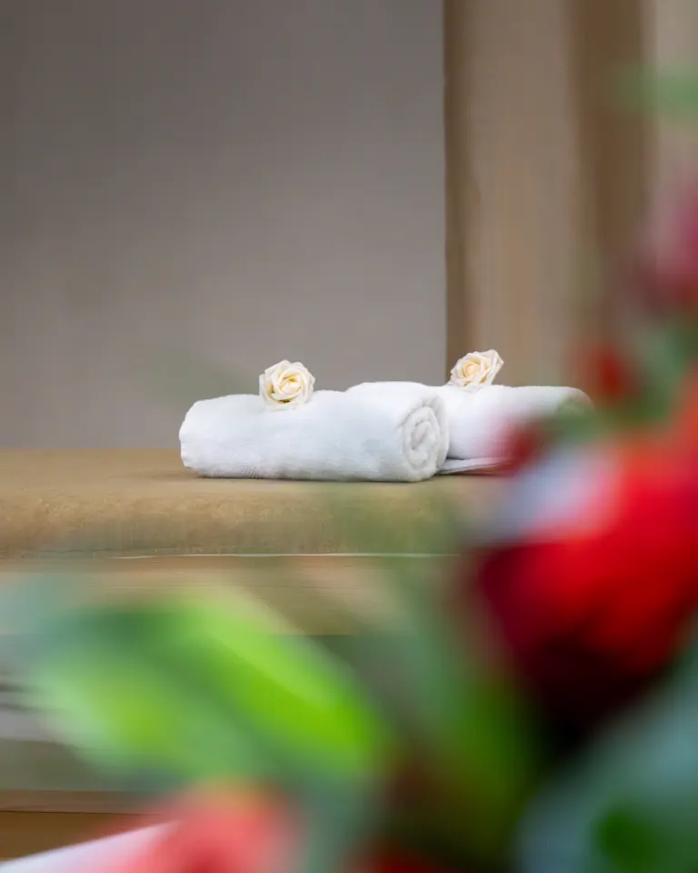 Serviettes sur la table de massage, roses rouges au premier plan