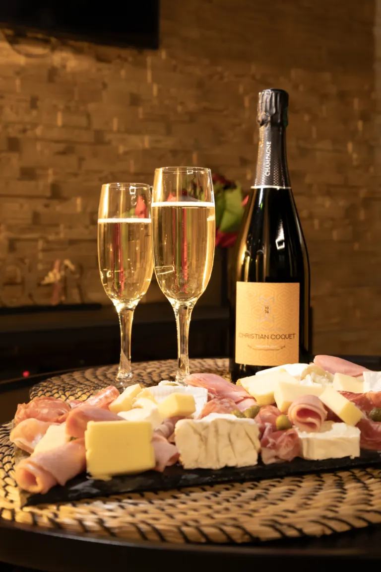 Champagne et planche apéritive sur la table basse du salon