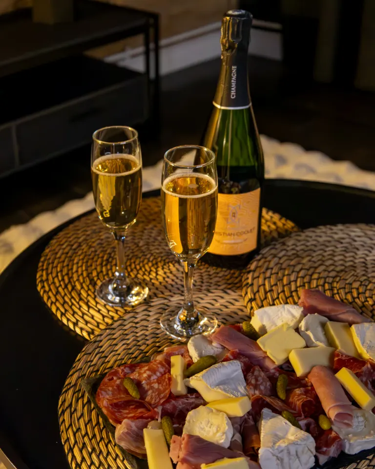 Coupes de champagne et planche de charcuterie et fromages dans le salon